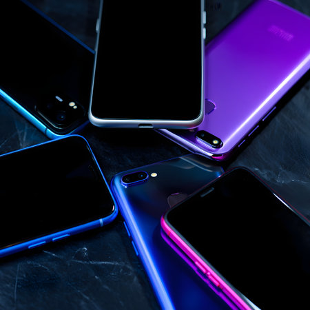 close up of mobile phones with blank screen on black marble table backgroundの素材