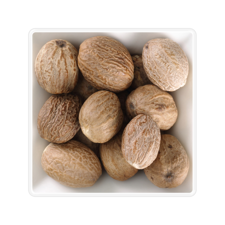 Nutmegs in square bowl on white backgroundの写真素材
