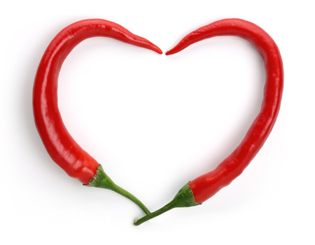 Heart shape made of red peppers, isolated on white backgroundの写真素材