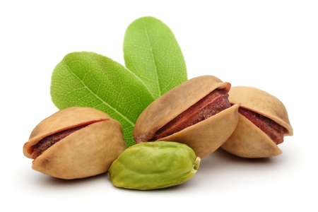 Pistachio nuts with leaves isolated on white backgroundの写真素材