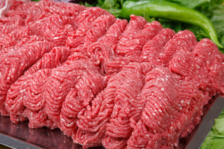 Uncooked ground beef steak and green pepperの写真素材