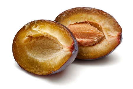 Two half Damson plums isolated on white backgroundの写真素材