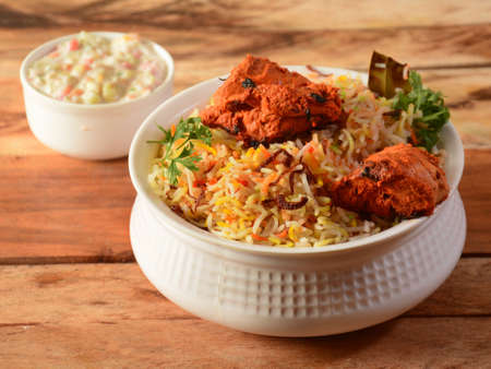 Chicken Tikka Biryani made of Basmati rice cooked with masala spices, served with yogurt, selective focusの写真素材