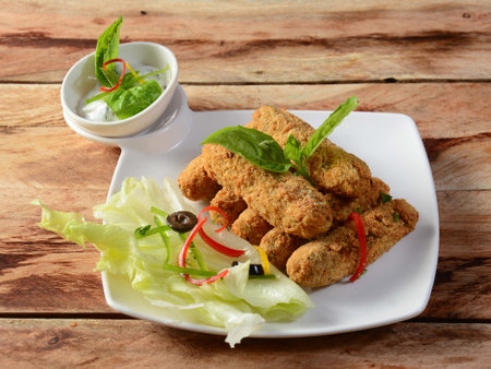 Tasty crispy fried fish fingers served on a ceramic white plate, selective focusの写真素材