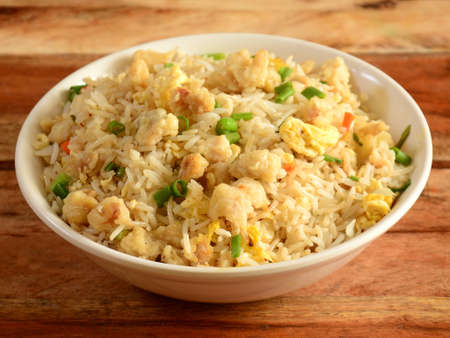 Indian cuisine Healthy and tasty chicken fried rice served in white bowl over a rustic wooden background, selective focusの写真素材