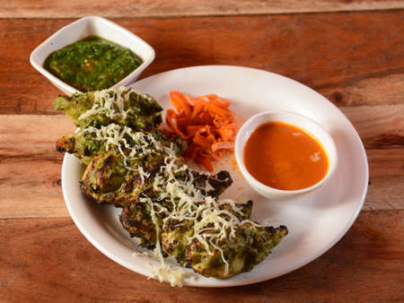 Chicken hariyali momo with sauce and mint chutney served over a rustic wooden background, selective...