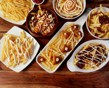 variety of assorted french fries on plates with mayonnaise and tomato sauceの写真素材