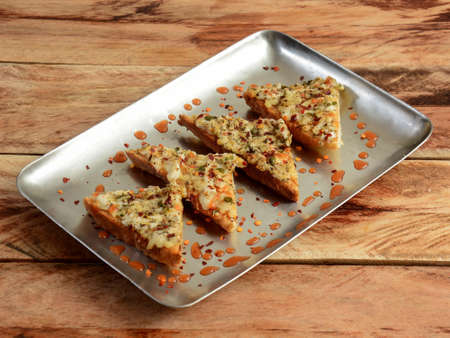Cheese Chilli Garlic Bread Pizza isolated over a rustic wooden background, selective focus