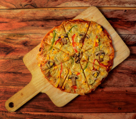 Mushroom Pizza on wooden pizza board, isolated over a rustic wooden background, selective focusの写真素材