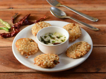 Sabudana vada or Sago fried cake served with chutney, popular fasting recipe from India. isolated...