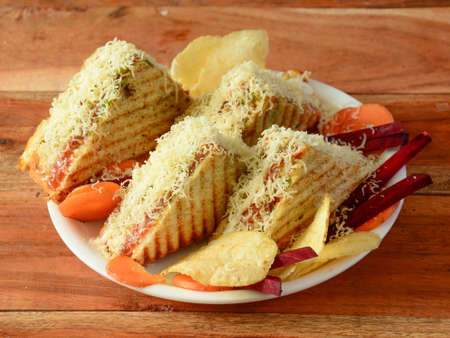 Veg cheese grilled sandwich served with ketchup, isolated over a rustic wooden background, selective focusの写真素材