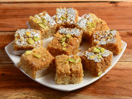 Kalakand is an Indian sweet is made from solidified, sweetened milk & paneer. served in a bowl with...