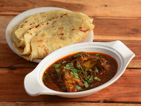 Chicken Thali from an indian cuisine, food platter consists of Chicken curry, roti and onions.,...
