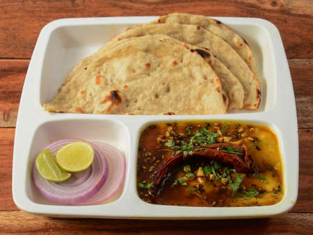 Indian combo meal Dal tadka with Naan, served over a rustic wooden background, selective focusの写真素材