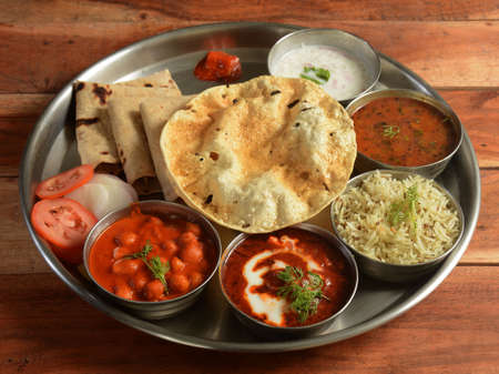 Punjabi Veg Thali from an indian cuisine, food platter consists variety of veggies, lentils, jeera rice, roti, sweet dish, curd, pickle etc., selective focusの写真素材
