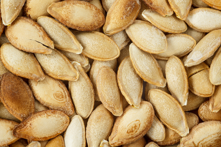 Close up of unshelled pumpkin seeds, roasted with salt. Healthy food backgroundの写真素材