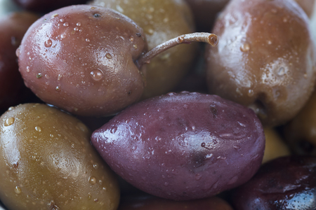 Close up of different varieties of olives with oil drops. Macro food backgroundの写真素材