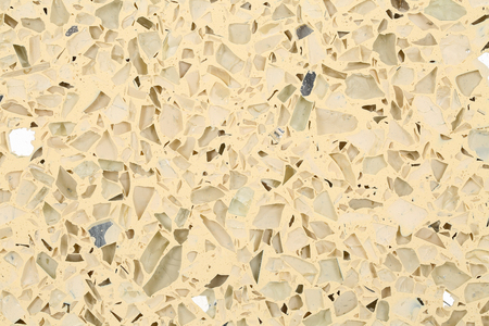 Close up of terrazzo flooring background texture with yellow base and glass, mirror and stone chipsの写真素材
