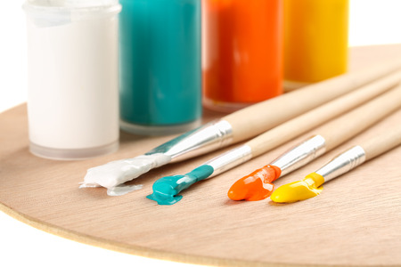 Extreme close up of art paint brushes with acrylic paint in vivid summer colors on a wooden paletteの写真素材