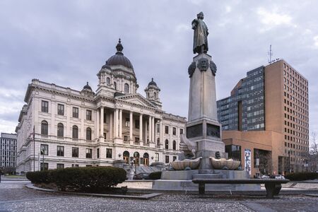 SYRACUSE, NY - JAN 14, 2020: Wide View of Columbus Circle Monument in Foreground and Onondaga County Courthouse & the Oncenter Civic Center Theaters in Background in Syracuse, New York.のeditorial素材