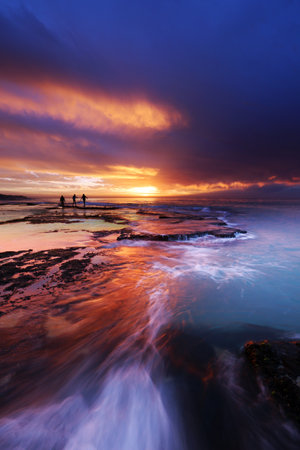 Seashore embraces the clouds with golden sunsetの写真素材