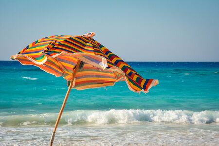 colorful umbrella in front of a wavy seaのeditorial素材