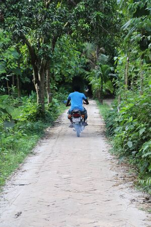 Village Road and Biker. Beautiful Village Road in Bangladeshの写真素材