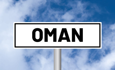 Oman road sign on cloudy sky backgroundの写真素材
