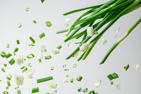 Cut green onion falling on a gray backgroundの素材
