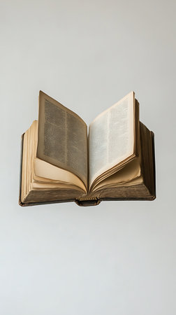 Displaying an old hardcover book opened on a neutral surface, showcasing the aged, yellowed pages filled with dense text. Manuscript and reading concepts.の素材