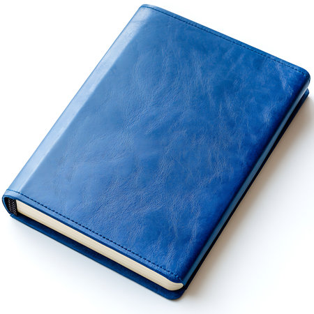 Still life shows a closed, elegant notebook with a blue leather cover, off-white pages, and a bookmark, presented on a clean white surface in an overhead shot.の素材