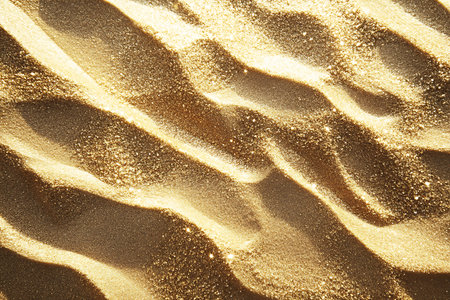 An abstract close-up image features a golden glittery surface. The pattern shows detailed texture with sparkling light enhancing the abstract view.の素材
