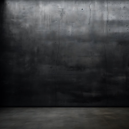 This image showcases a heavily textured, dark gray wall with cracks and signs of aging above a smooth, dimly lit floor surface, evoking a sense of decay.の素材
