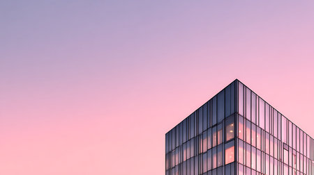 Low angle view showcasing a glass-covered modern building against a dreamy pink and purple gradient sky at dusk. The windows reflect the soft glow of the setting sun.の素材