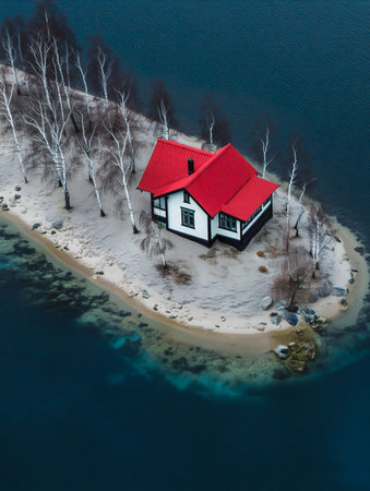 Small isolated house with red roof on a tiny island surrounded by waterの素材