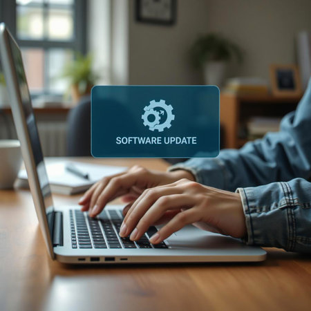 Person typing on laptop with software update notification on screenの素材