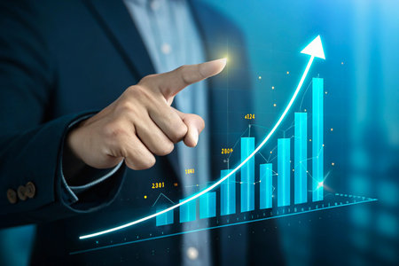 Businessman pointing at a glowing upward trending financial graphの素材