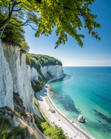 Dramatic white chalk cliffs meet a clear turquoise sea, with lush green trees framing the stunning coastal landscape.の素材