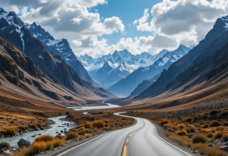 Winding mountain road through a dramatic valley under a cloudy skyの素材