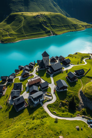 Picturesque alpine village nestled beside turquoise mountain lakeの素材