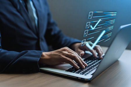 Businessman working on laptop with digital checklist and growth graphの素材