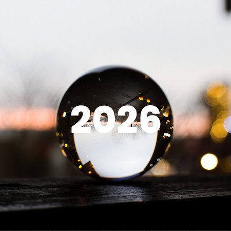 A clear crystal ball displays the year 2026, set against a backdrop of blurred bokeh lights.の素材