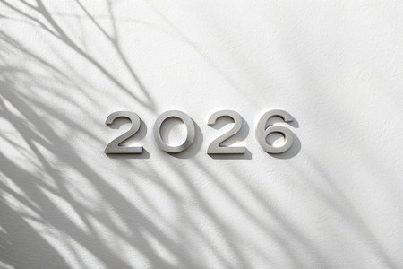 Metallic 2026 numbers are centered on a textured surface with abstract shadow patterns.の素材