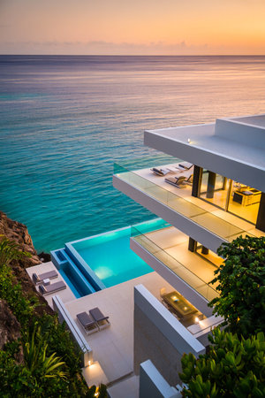 A stunning modern villa with an infinity pool and ocean views, bathed in the warm glow of a sunset.の素材
