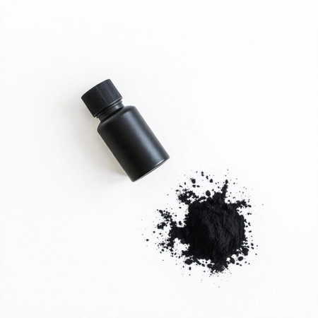 Black cosmetic bottle with black powder isolated on white background. Top view.の素材