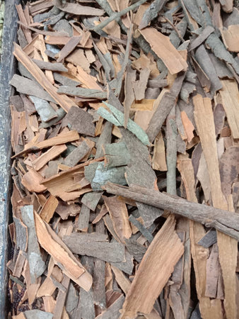 The image depicts a close-up view of a pile of wood chips. The chips are of various shades of brown...
