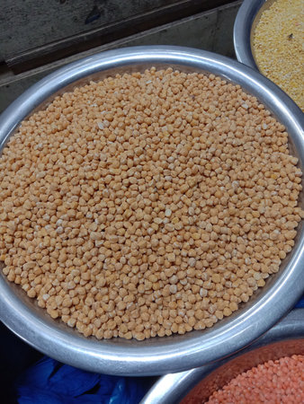 The image shows a large metal bowl filled with grain. The bowl is placed on a countertop, and the...