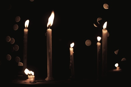 Seven burning candles with bokeh in the background.の写真素材