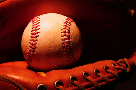 A lightpainted photo of a baseball sitting in catcher's mittの写真素材