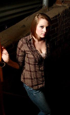 A young woman in a shadowy alleyの写真素材